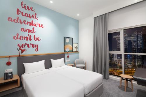 a bedroom with a bed and a sign that reads live travel adventure and dont be at Rove City Walk in Dubai