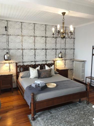 a bedroom with a bed and a chandelier at La Casa Verde B&B in Trivero