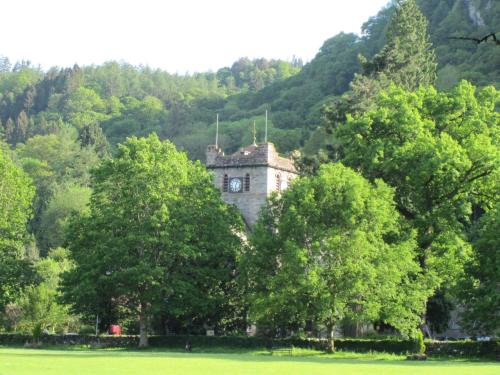 an old house surrounded by trees in a field at The Courthouse in Betws-y-coed