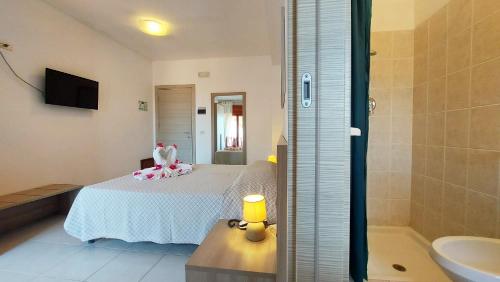 a bedroom with a bed and a bathroom with a tub at Hotel Residence Costa Azzurra in Capo Vaticano