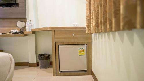 a kitchen with a white refrigerator under a counter at RoomQuest Suvarnabhumi Airport Romklao Soi 6 in Lat Krabang