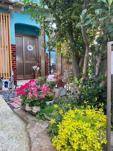a garden with flowers in front of a house at 幽舍の庭 in Izumi-Sano