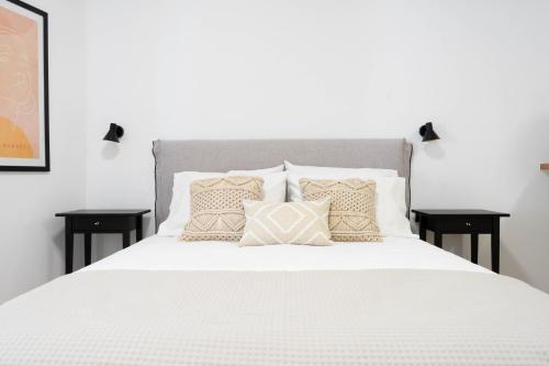 Marilias Luxury Studio Apartment في كيساموس: غرفة نوم بسرير ابيض عليها مخدات