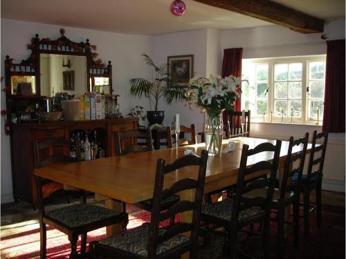 una sala da pranzo con tavolo e sedie in legno di Splatthayes a Buckerell