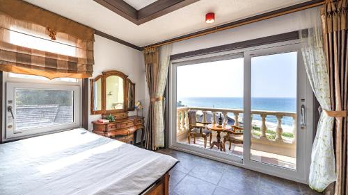 a bedroom with a bed and a large window at Pension Badawa in Gangneung