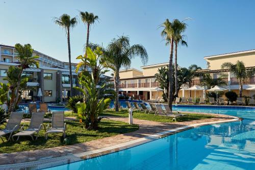 a pool at the resort with palm trees at Atlantica Aeneas Resort in Ayia Napa