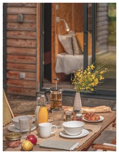 Una mesa de madera con comida y bebidas encima. en Volvic Organic Resort, en Volvic