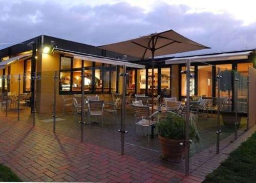 a building with tables and chairs and an umbrella at Richmond Henty Hotel in Portland