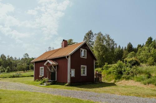 a red house in a field with trees at Kylås Vildmark in Skillingaryd