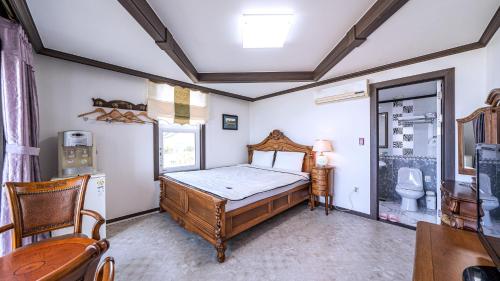 a bedroom with a bed and a toilet in it at Pension Badawa in Gangneung
