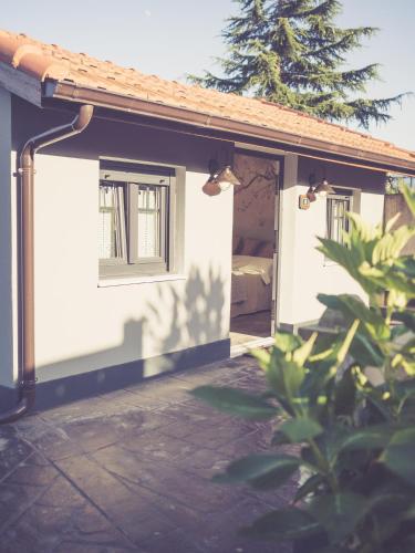 a house with two windows and a bed in it at Hotel Rural La Casa DelBelga in Muskiz