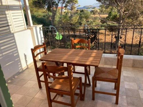 a wooden table and chairs on a balcony at SMAG Suites in Agios Petros