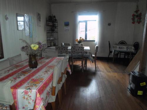 Una habitación con dos mesas con flores. en Hospedaje Teresita, en Puerto Montt