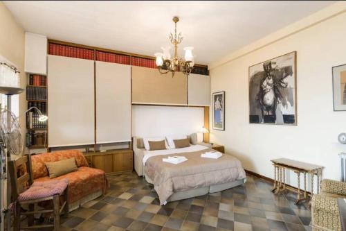 ein Schlafzimmer mit einem Bett, einem Sofa und einem Stuhl in der Unterkunft Ano Poli stay with private terrace and view in Thessaloniki