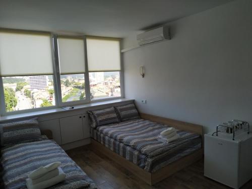 two beds in a room with two windows at Top center Deluxe apartment in Gabrovo