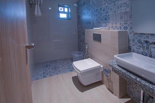 a bathroom with a toilet and a sink and a shower at Hotel Park Tree, NEAR 5 STAR MIDC, KANERIWADI, NH4 GOA HIGHWAY KOLHAPUR in Kolhapur