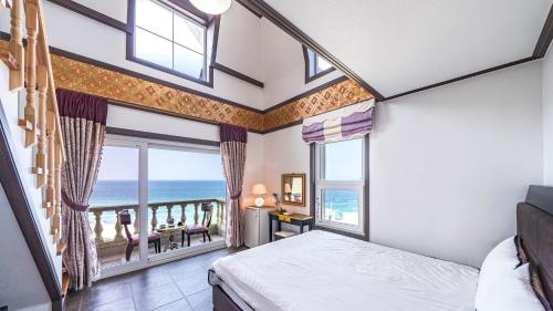 a bedroom with a bed and a view of the ocean at Pension Badawa in Gangneung