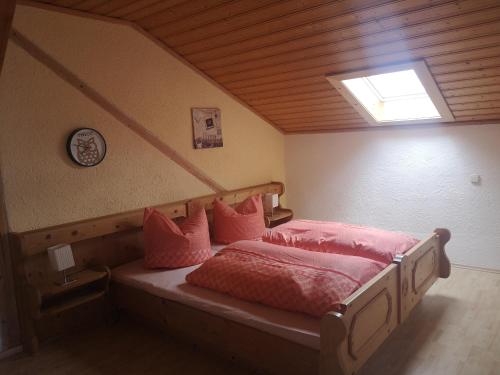 Un dormitorio con una cama con almohadas rosas. en Hanneshof, en Riedlhütte