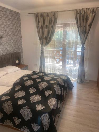 ein Schlafzimmer mit einem Bett und einem großen Fenster in der Unterkunft MOTEL Restaurant NICOL ARMENIS in Armeniş