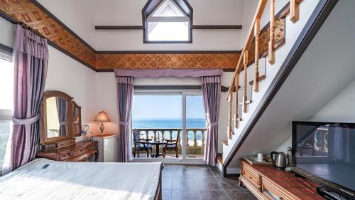 a bedroom with a bed and a view of the ocean at Pension Badawa in Gangneung
