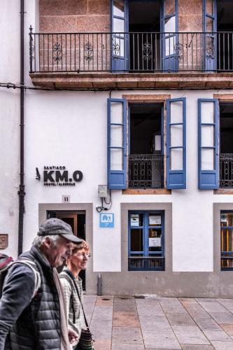 two people walking down a street in front of a building at Santiago KM-0 in Santiago de Compostela