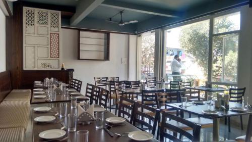 a dining room with tables and chairs and a window at Hotel SRI SRI EXECUTIVE KOLHAPUR NEAR MAHALAXMI TEMPLE in Kolhapur