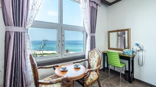 a room with a table and chairs and a window at Pension Badawa in Gangneung