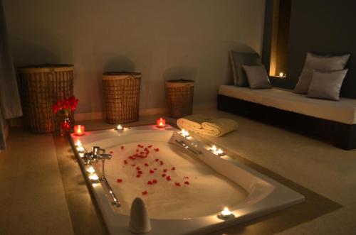 a bathroom with a tub with lights and a bed at Villa Loanaelle in Marrakesh