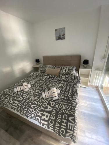 a bedroom with a bed with a black and white bedspread at Apartman OMAR stan na dan besplatan parking Sarajevo in Sarajevo