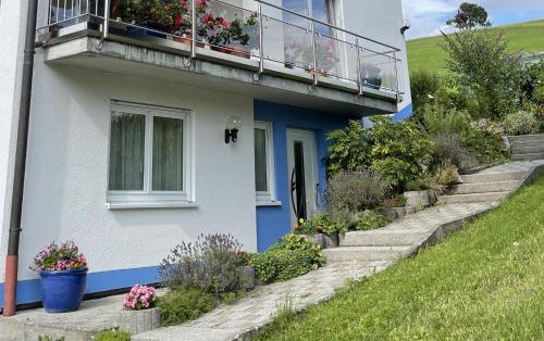 een blauw-wit huis met een balkon bij Ferienwohnung - Haus Waibel in Überlingen