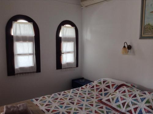 a bedroom with two windows and a bed at Mouria Hotel in Skiathos Town