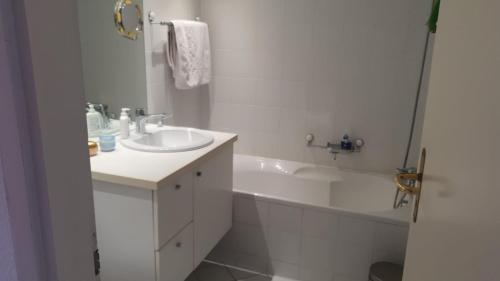 a white bathroom with a sink and a bath tub at Golfo d'Oro in Ascona