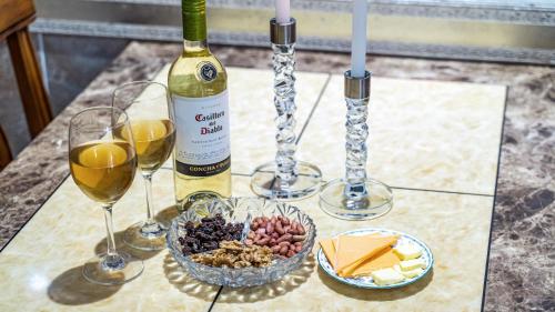 a table with a bottle of wine and wine glasses at Pension Badawa in Gangneung