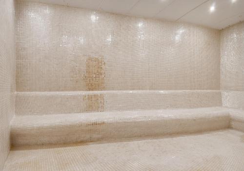 a bathroom with a bath tub with tiled walls at TNR Otel & Spa in Kusadası