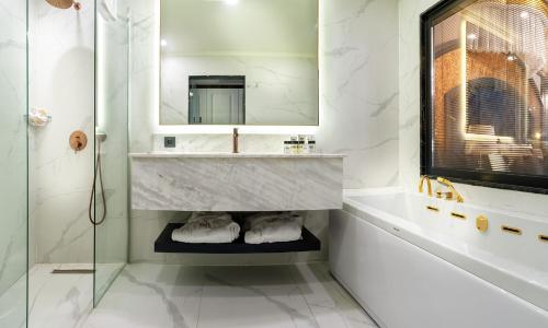 a bathroom with a sink and a mirror at TNR Otel & Spa in Kusadası