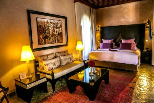 a bedroom with a king sized bed and a couch at Riad Fes - Relais & Châteaux in Fès