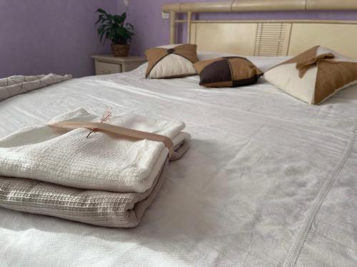 a large white bed with pillows and towels on it at Chambre d'hôte in Fay-les-Étangs