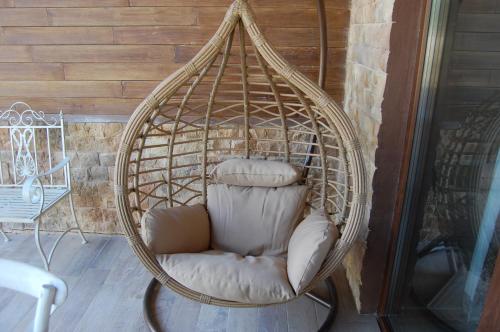 a wicker swing chair sitting on a porch at Las Villas de Fuentidueña in Fuentidueña