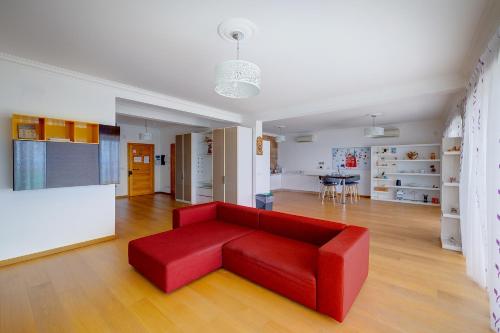a red couch in a living room with a table at Seafront Apartment in Sliema with Pool, Upmarket Complex in Sliema