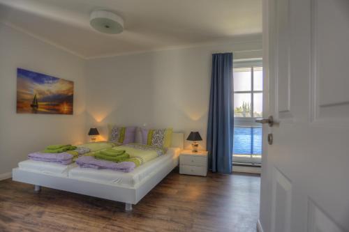 een slaapkamer met een bed en een raam bij Villa Namenlos in Börgerende-Rethwisch