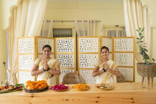 Deux femmes debout devant une table avec de la nourriture dans l'établissement Maharishi Ayurveda-Boutique Wellness Retreat, à Rishikesh