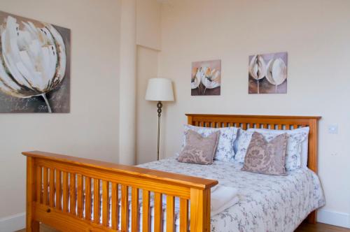 a bedroom with a wooden bed with four pictures on the wall at Stunning View - Jura - Private Members Club in Edinburgh