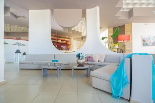 a living room with a couch and tables at Happy Days Hotel, Adults Only in Theologos