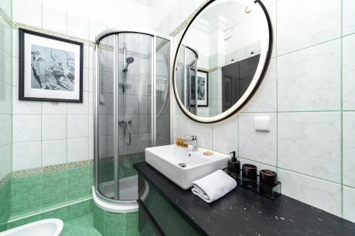 a bathroom with a sink and a mirror at Trzy Gracje - Monte Cassino by OneApartments in Sopot