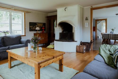 a living room with a coffee table and a fireplace at Kylås Vildmark in Skillingaryd