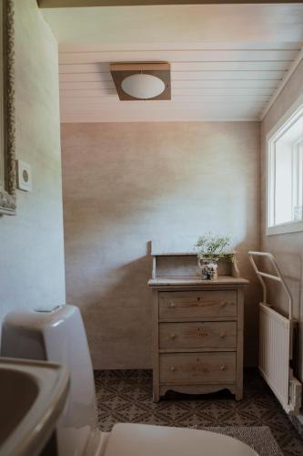a bathroom with a sink and a wooden dresser at Kylås Vildmark in Skillingaryd