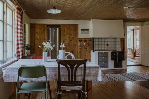 a kitchen and dining room with a table and chairs at Kylås Vildmark in Skillingaryd