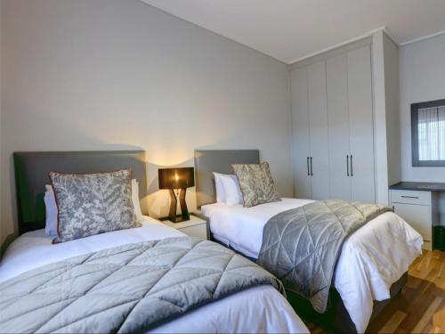 1 dormitorio con 2 camas y mesa con lámpara en Harvil House en George