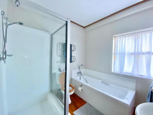 a bathroom with a shower and a toilet and a sink at Melkbos Beach Cottage in Melkbosstrand