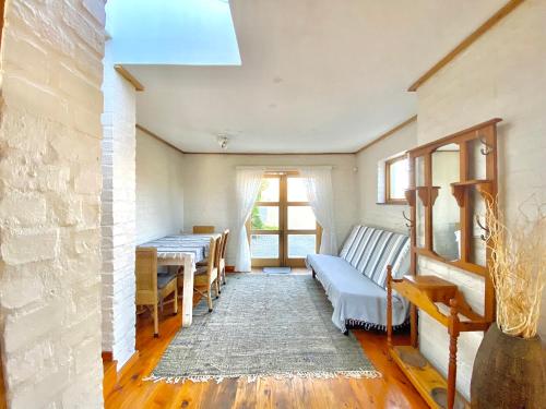 ein Wohnzimmer mit Sofa und Tisch in der Unterkunft Melkbos Beach Cottage in Melkbosstrand